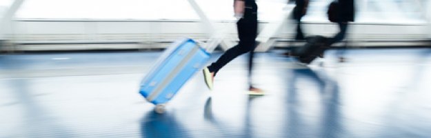 Reisende mit Koffer am Flughafen